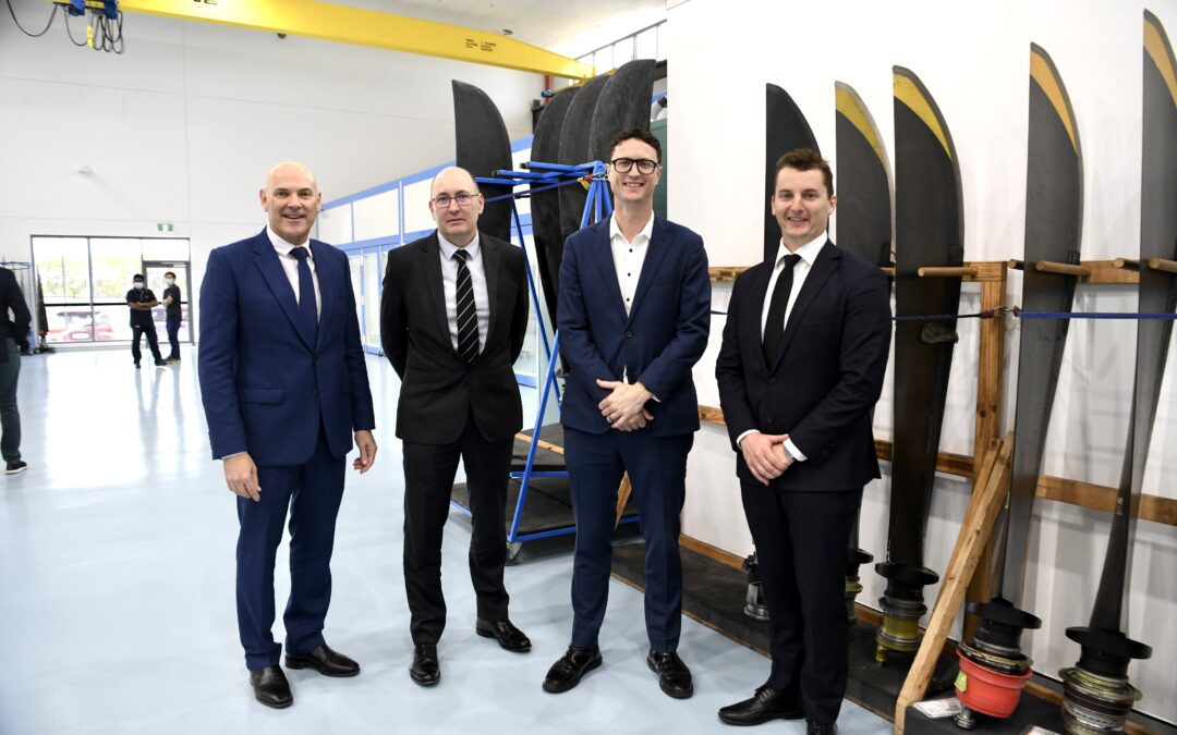 Men standing in front of Dowty propeller products at Brisbaen opening